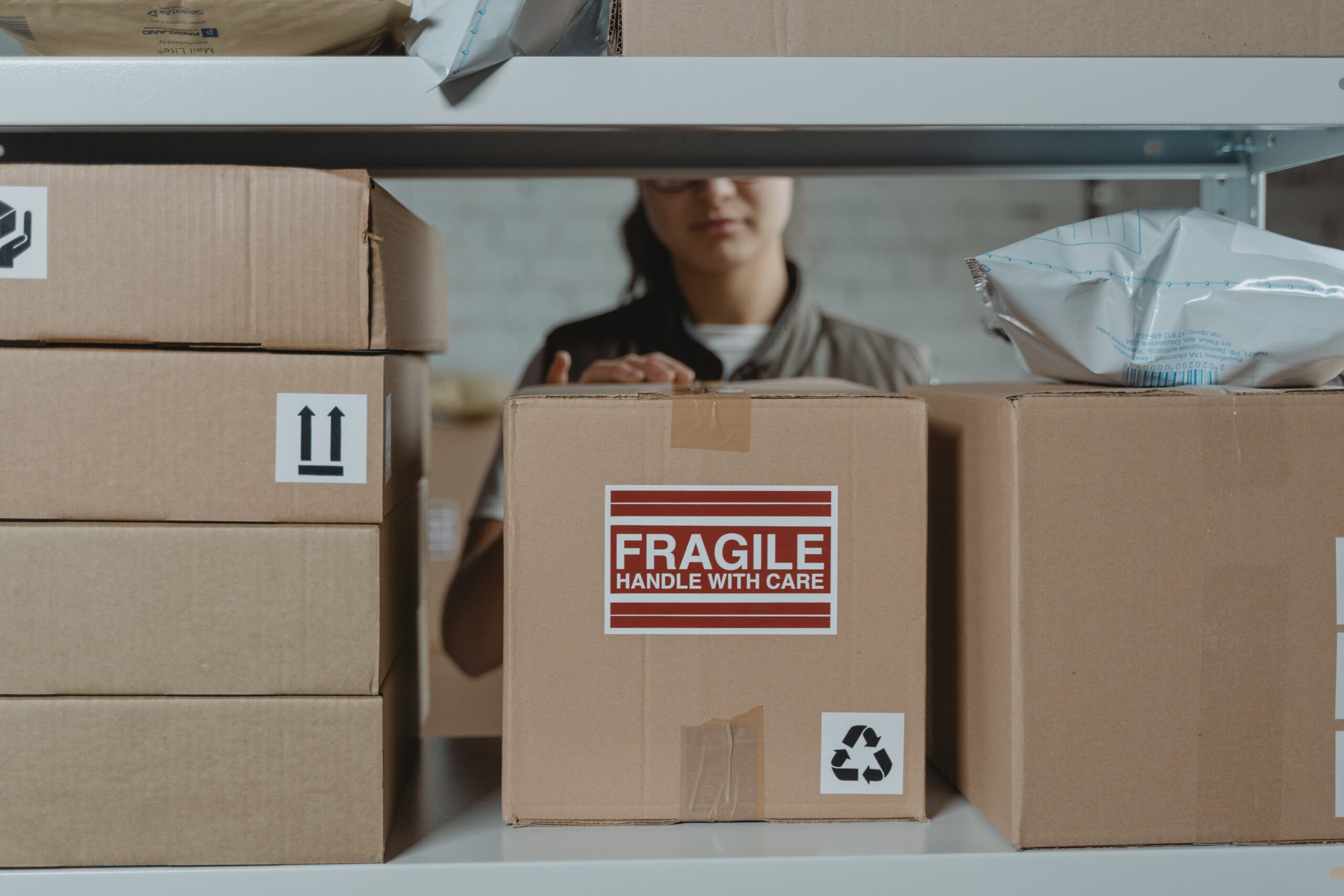 girl packing box with fragile sticker